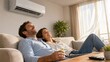 © W.O.W - Man and woman relaxing on sofa at home under air conditioner. Happy couple enjoying cool breeze in living room. Household climate control and summer heat relief in modern apartment.