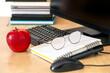 © Svitlana - Healthy workplace with fresh red apple, notebook, eyeglasses and computer on office desk. Concept of productivity, healthy snack, workplace wellness and balanced work lifestyle.
