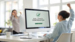 © Moni - Woman celebrating bank transfer confirmation on computer in office with colleague monitor