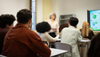 © VictorCanalesStudio - Mature teacher giving a presentation to diverse students in a modern classroom