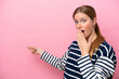 © luismolinero - Young caucasian woman isolated on pink background with surprise expression while pointing side