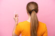 © luismolinero - Young caucasian woman holding invisaging isolated on pink background in back position