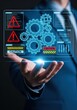 © Hungarian - Businessman holding a futuristic digital hologram of gears and caution signs for industrial system maintenance and risk management