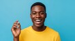 © twilight mist - Happy Young African American Man Snapping Fingers and Smiling Broadly Against Blue Background