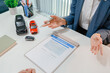 © PHOTO4U - Professional car sales consultation with a customer reviewing documents, discussing vehicle options, signing purchase agreements, and handing over car keys in a modern dealership office.