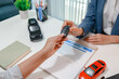 © PHOTO4U - Professional car sales consultation with a customer reviewing documents, discussing vehicle options, signing purchase agreements, and handing over car keys in a modern dealership office.