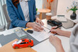 © PHOTO4U - Car purchase transaction with payment, contract signing, key handover, and customer agreement in a modern dealership office, representing automotive sales, business finance, and professional service.