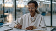 © forenna - Ethiopian woman assembles lithium battery cell modules at a manufacturing workstation, placing electrode stacks with precision tweezers, wearing anti-static wrist straps and