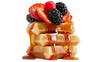 © Anneliese - Stack of Belgian waffles with fresh strawberries raspberries, and blackberries drizzled with syrup