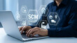 © Mdromjan22 - Businessman using laptop with SCM supply chain management system icons