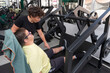 © Oriol Llauradó Ballesta/Stocksy - Person performing adapted training in gym with personal trainer