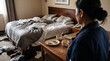 © Olga Ко - Over the shoulder view of a hotel maid looking at a very messy and dirty hotel room. Concept of housekeeping, cleaning service, and the aftermath of untidy guests