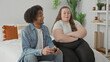 © Krakenimages.com - Man plays with joystick while woman sits arms crossed on bed in building; relationship tension frustration.