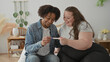 © Krakenimages.com - Woman hands a pregnancy test to man while both smile and touch on a bed in studio; joy anticipation.