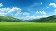 © Badrul - Expansive green field under a brilliant blue sky with scattered clouds, framed by rolling mountains
