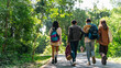 © CandyRetriever  - Group of Generation z people friends hiking through forest trail exploring nature together during eco travel adventure enjoying outdoor recreation sustainable tourism and healthy active lifestyle