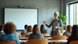© Lubov - Woman speaks to audience in classroom. Speaker presents material on screen. Students listen and learn in modern seminar room. Teacher at lecture.