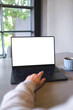 © Farknot Architect - Vertical mockup image of a woman working and typing on laptop computer with blank white desktop screen in cafe