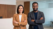 © Kaluya Stock - Smiling diverse business professionals standing with arms crossed in modern corporate office