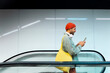 © VISTA by Westend61 - Man uses smartphone on escalator during urban commute