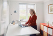 © BusinessClass by W61 - A woman types on a laptop at a standing desk in a home office