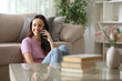 © PheelingsMedia - Happy woman talking on phone looking at side at home