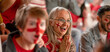 © Halfpoint - Excited senior woman football fan supproting English national team in live soccer match at stadium.
