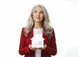 © Iksan Picture - A mature woman with silver hair wears a professional red blazer while she holds a small residence model and thoughtfully looks upward to visualize her future dream living space for retirement