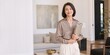 © Vasiliy - Professional Asian businesswoman holding a folder in an elegant interior. Confident female real estate agent or interior designer