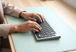 © stefanholm - Medium wide shot of two hands typing on a futuristic programming keyboard over a pale mint desk mat.