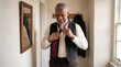 © Lambic - African American man tying necktie in mirror - Mature black man adjusting his tie while getting dressed indoors