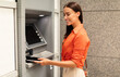 © Prostock-studio - Financial transactions, money withdrawal. Smiling lady putting phone to ATM machine reader, withdrawing cash from bank account in urban area outside. Customer uses smartphone to gain access to ATM