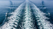 © jendralbiribiri - Boat wake trail behind a large vessel moving across deep blue ocean water on a bright sunny summer day