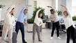 © Jafree - Office colleagues doing workplace stretching exercise for employee wellness during movement break. Diverse team of women and men practicing healthy yoga posture in modern business office