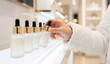 © CK Studio - Skincare product, hand selecting elegant dropper bottle from illuminated retail display, illustrating beauty and self-care shopping experience.