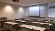 © Arifah - Empty classroom with rows of tables, chairs, a projector, and whiteboards