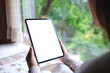 © Farknot Architect - Mockup image of a woman holding tablet with blank desktop white screen on the bed at home