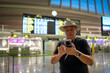 © Nazareno - Traveler checking flight information on smartphone at airport