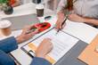 © PHOTO4U - Professional car sales consultation with a customer reviewing documents, discussing vehicle options, signing purchase agreements, and handing over car keys in a modern dealership office.