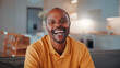 © peopleimages.com - Happy, relax and face of black man on sofa in home for break with funny weekend in morning. Smile, confident and portrait of person with laughing for positive attitude in living room at house.