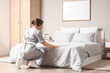 © Pixel-Shot - Beautiful young chambermaid making bed in stylish bedroom