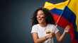 © Vera D - Excited curly woman holding Colombia national flag on pole, happy Colombian sports fan celebrating soccer football victory on grey background portrait