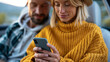 © Nataliya - Faceless young couple using phone on road trip together checking social media, travel lifestyle concept, automotive photography, blurred outdoor background, with copy space