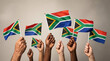 © GraphicLoom - Hands holding South African flags for Nelson Mandela Day