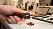 © Mahmuda - Professional makeup artist sharpening lip liner pencil | Close up of hand using cosmetic pencil sharpener | Beauty routine and makeup application preparation | Wood shavings from eyeliner on marble