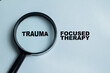 © syahrir - Concept of trauma focused therapy write on clipboard isolated on Wooden Table. For PTSD recovery and psychologist supporting patient through emotional healing
