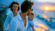 © Aliaksandra - Happy family relaxing together on a sunny beach, viewed from behind, with parents and two children overlooking the blue sea
