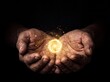 © AdPremium - Weathered hands cupping a glowing golden energy orb with sparkling particles against a black background