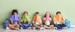 © Pixel-Shot - Group of diverse children sitting with colorful notebooks