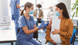© Prostock-studio - Pregnant asian lady sitting at doctor's office getting modern anti flu shot, hugging belly. Nurse in medical face mask and gloves holding syringe and giving patient vaccine injection in arm
